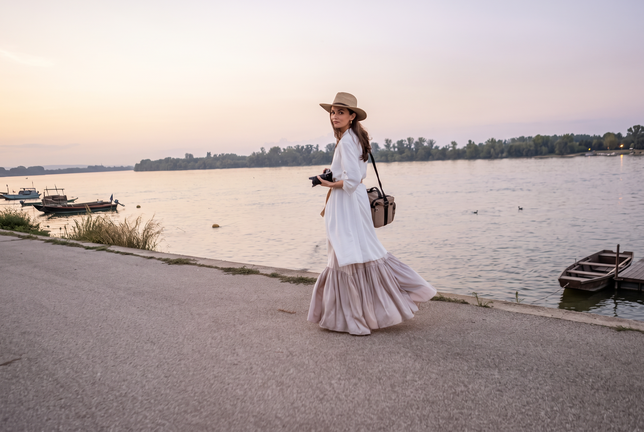 Milica Karan by the river at sunset holding a camera